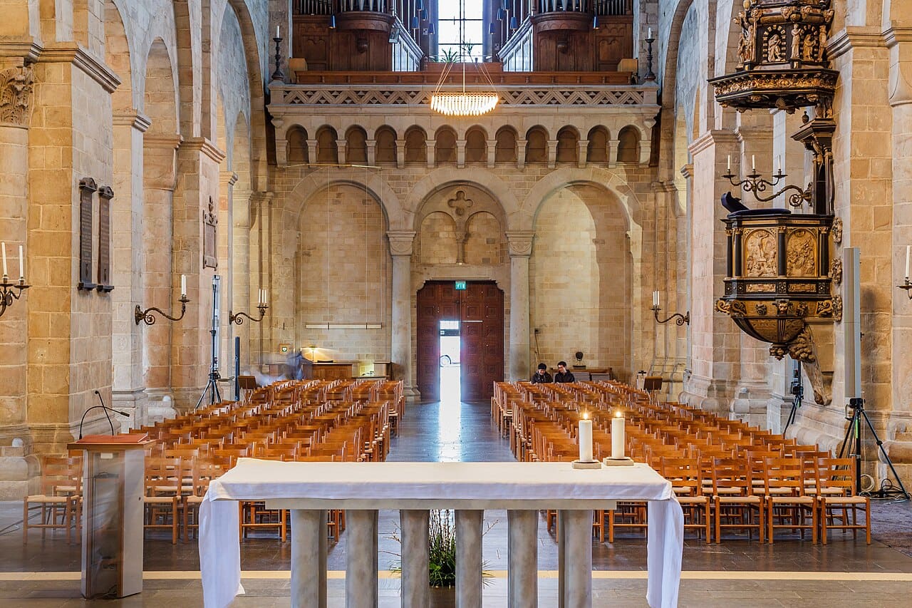 Midtskipet i Lunds domkirke med alter, tente lys og stolrader
